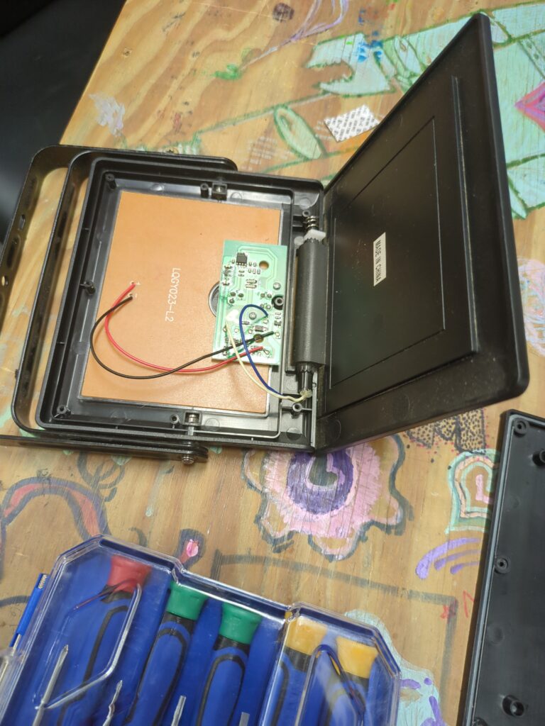 A solar powered motion activated light, disassembled to show the electronics inside.