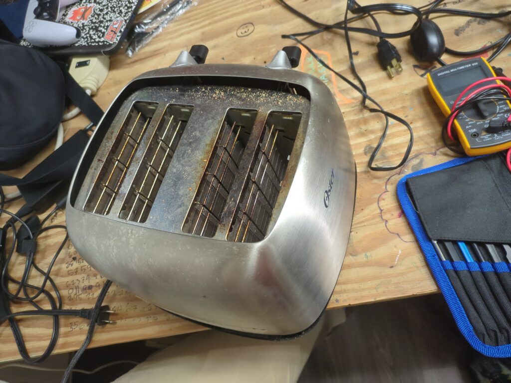 A beautiful brushed metal toaster with 4 slots for bread.