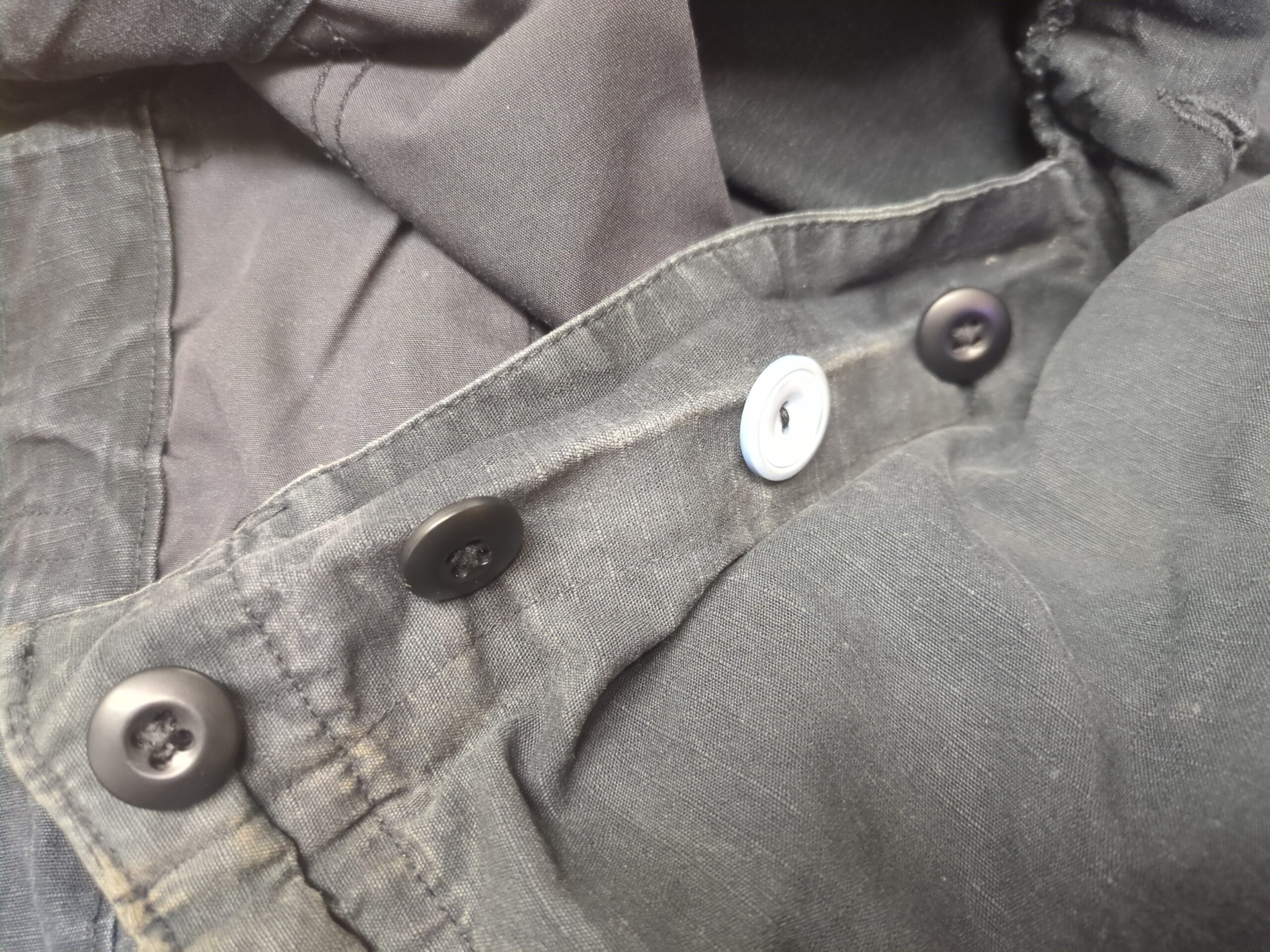 A pair of pants with one button that has been replaced