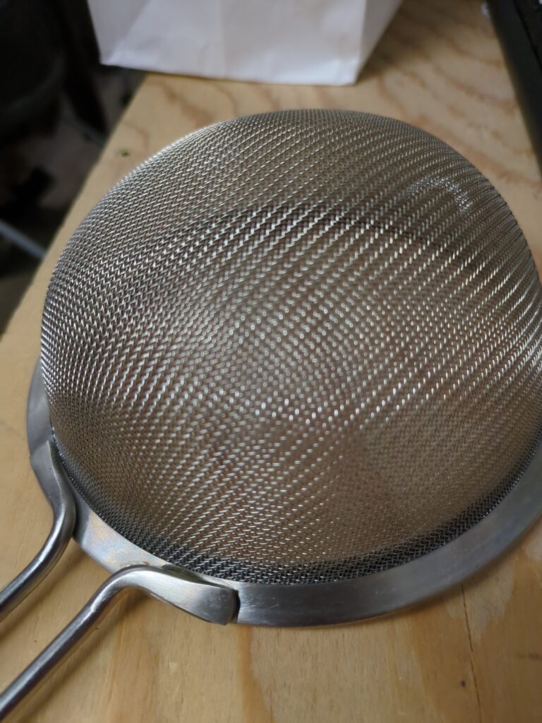 The welds on strainers break sometimes. This one has been epoxied back together. Upon close inspection, the bead of epoxy is visible on the right hand side of the handle.