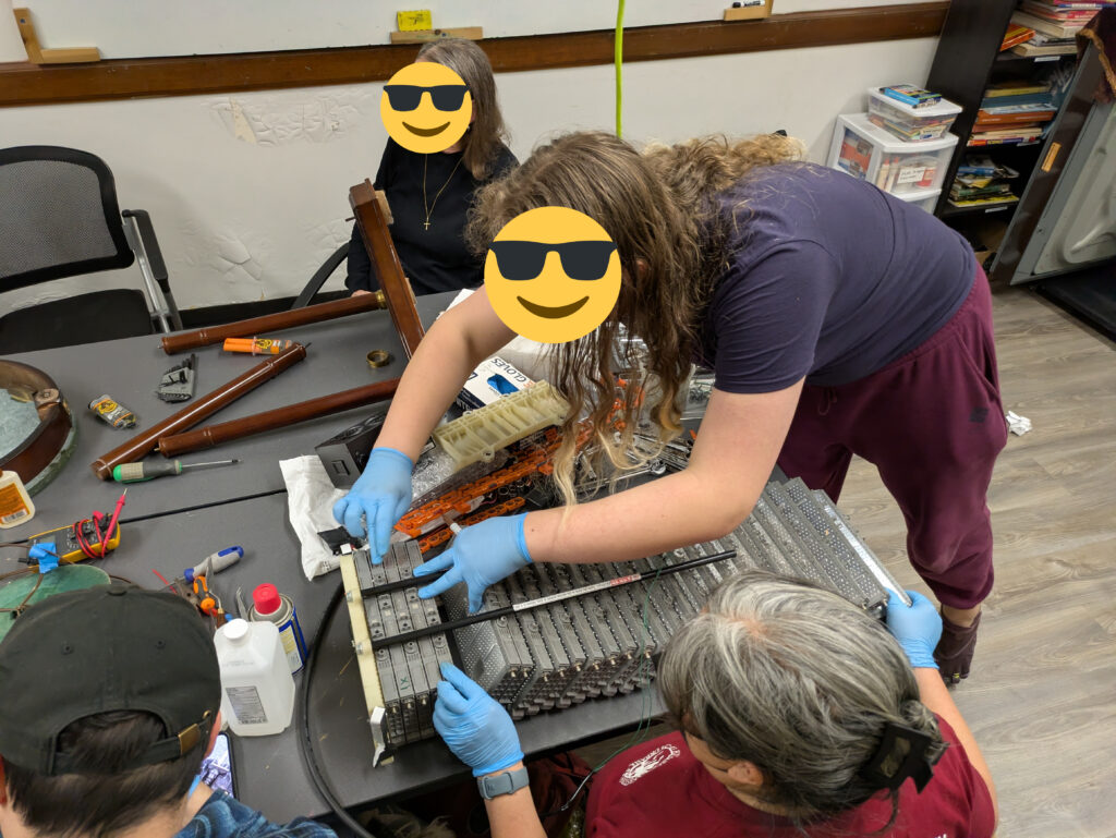 Two ladies separating the cells of the EV's battery pack