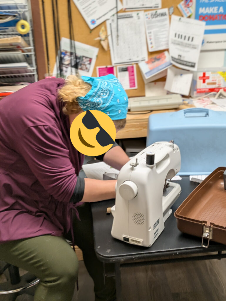 A mentor is sewing... something. This might have been part of the jacket pocket repair that we didn't get good pictures of... or maybe something else, there was a fair amount of sewing going on this month.