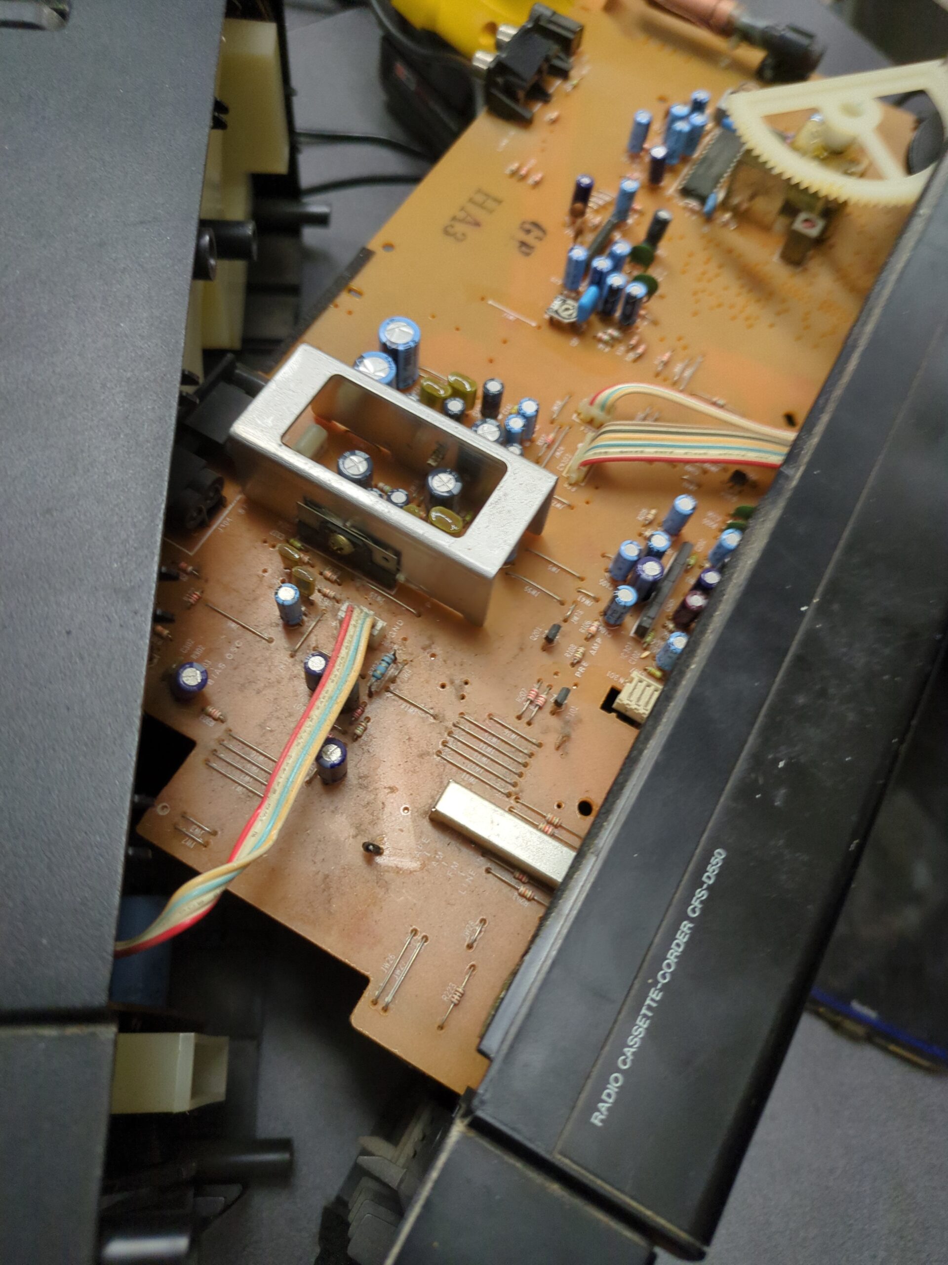 A circuit board inside a boom box that is 30 to 40 years old. Components are easily identifiable and replaceable.